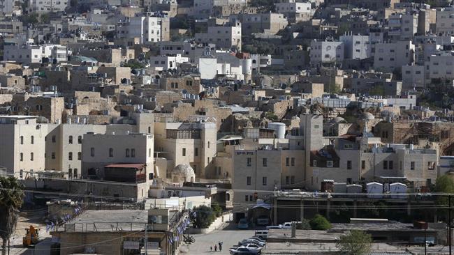The photo taken on April 6, 2017 shows a general view of the Israeli settlement of Abraham Avino (back) in the center of the Old City of the Palestinian city of al-Khalil (bottom) in the occupied West Bank. (Photo by AFP)
