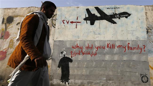 A Yemeni man walks past a mural depicting a US drone and reading ‘Why did you kill my family.