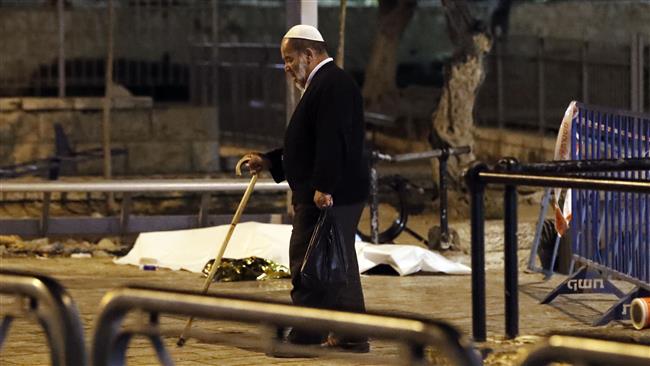 An elderly Palestinian man walks past the body of a Palestinian teenager shot dead following an alleged stabbing attack outside the Damascus Gate entrance to the Old City of Jerusalem al-Quds on June 16, 2017. (Photo by AFP)
