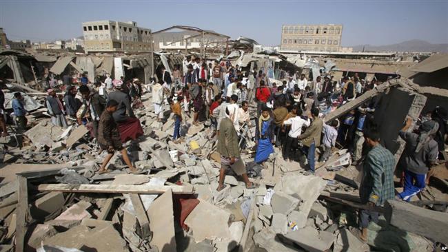 People gather on the rubble of shops destroyed in a Saudi airstrike at a market in Sana