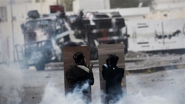 File photo shows Bahraini protesters taking cover during a confrontation with police after a demonstration.
