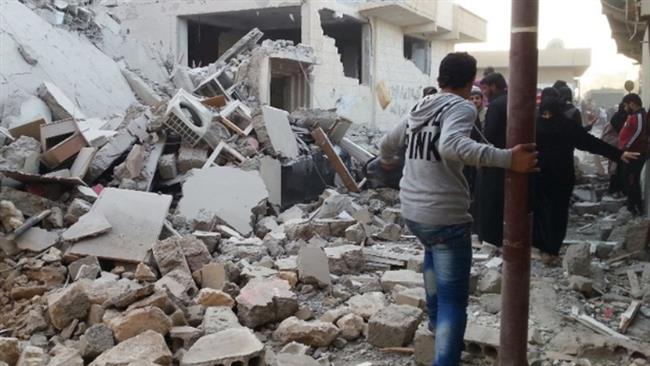 People walk past a building reportedly targeted by US warplanes in the Syrian city of Raqqah. (Photo by AFP)
