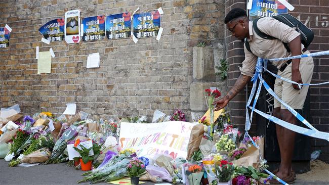 A man leaves flowers beside the police cordon, close to the scene of a van attack in Finsbury Park, north London on June 19, 2017. (Photo by AFP)

