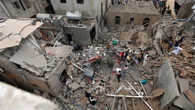 Yemenis stand on the rubble of houses destroyed in a Saudi airstrike in the capital Sana