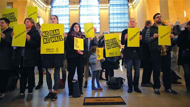 People stand holding placards as they take part in a protest called No Ban! No Wall! Get Loud, hosted by Amnesty International USA, inside Grand Central Station in New York City ,on March 3, 2017. (AFP photo)
