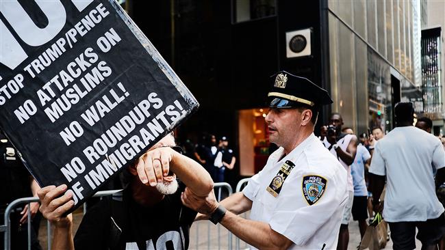 A protester scuffles with a police officer outside of Trump Tower following an announcement by the Supreme Court that it will take President Donald Trump