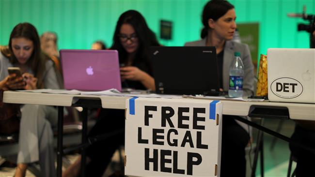 Volunteer lawyers set up a table to help arriving passengers with the reinstatement by the US Supreme Court of portions of President Donald Trump