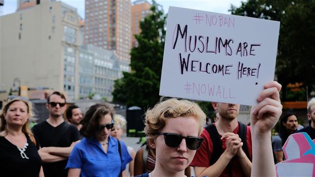 Recent immigrants join activists for an evening protest in Manhattan hours before a revised version of President Donald Trump