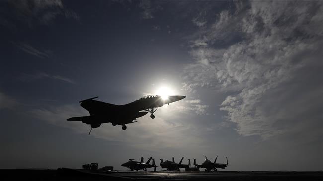 In this picture, a US Navy fighter jet lands on the deck of an American aircraft carrier. (By AP)