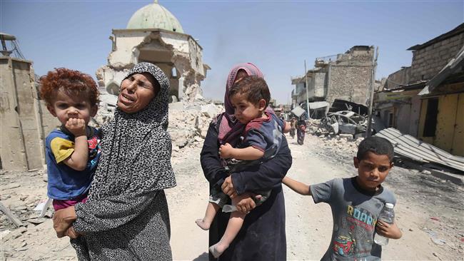 Iraqis walk by the destroyed Al-Nuri Mosque as they flee from the Old City of Mosul on July 5, 2017. (Photo by AFP)
