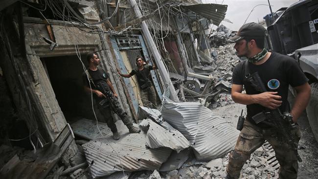 Members of the Iraqi Counter Terrorism Service stand amid destroyed buildings in the Old City of Mosul on July 7, 2017, during the Iraqi government forces