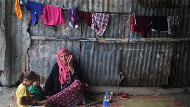 A Palestinian woman sits with her grandchildren outside her house in a refugee camp in southern Gaza Strip on July 11, 2017. (Photo by Reuters)
