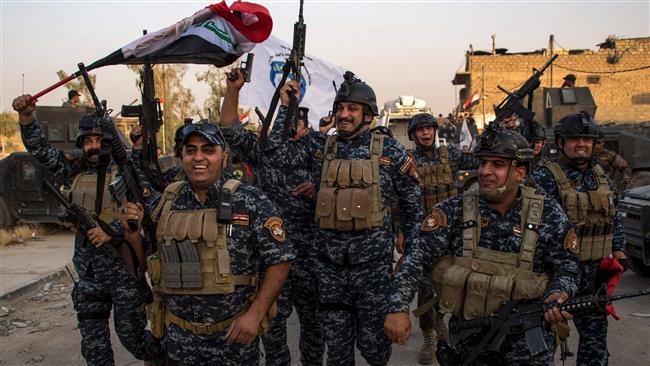 Members of the Iraqi federal police celebrate in the Old City of Mosul on July 10, 2017 after the government