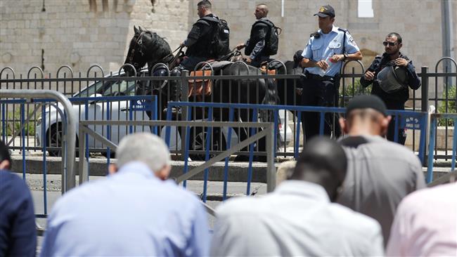 Israeli forces stand guard as Muslim worshippers pray outside the Damascus Gate, a main entrance to the Old City of Jerusalem al-Quds, on July 14, 2017, after the al-Aqsa Mosque was closed for Friday prayers by Israeli authorities following a shootout. (Photo by AFP)