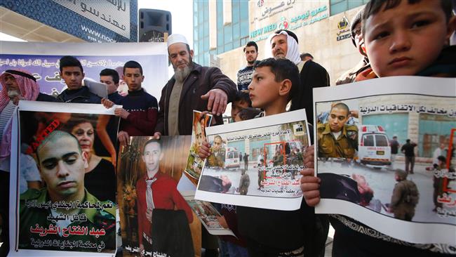 Palestinians holds placards during a demonstration following a verdict in the trial of the Israeli soldier Elor Azaria (portrait-L) who in March 2016 shot dead wounded Palestinian Abel Fattah al-Sharif (portrait-C) in the West Bank city of al-Khalil (Hebron) on February 21, 2017. (Photo by AFP)