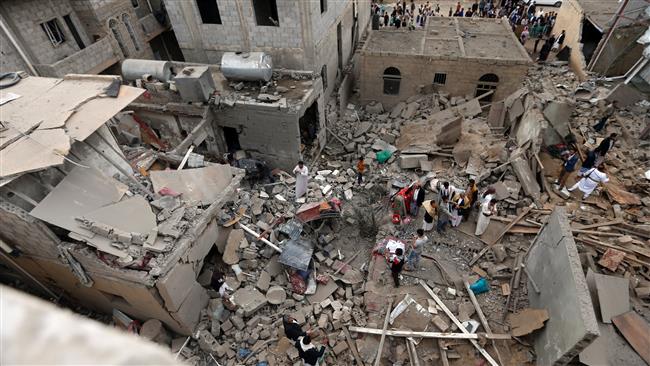 Yemenis stand on the rubble of houses destroyed in a Saudi airstrike in Sana