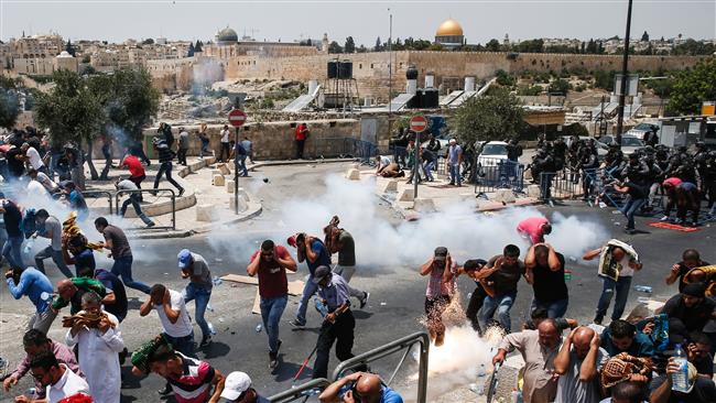 Palestinian worshipers run for cover from teargas fired by Israeli forces outside Jerusalem al-Quds’ Old City in front of the al-Aqsa mosque compound on July 21, 2017.