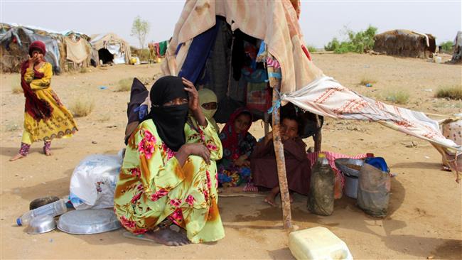 Yemenis displaced by Saudi Arabia’s airstrikes sit under a makeshift shelter at a camp for internally displaced persons in the northern district of Abs in Yemen