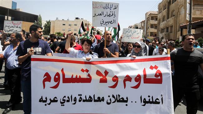 Jordanian protesters hold a banner reading in Arabic "resist and do not compromise, declare the annulment of the Wadi Araba [peace] treaty" with Israel, during a demonstration near the Israeli embassy in Amman on July 28, 2017. (Photo by AFP)
