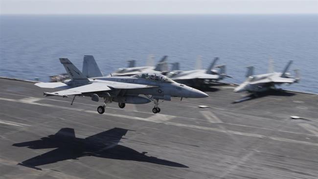 In this file photo, A US plane lands on the flight deck of the USS Theodore Roosevelt aircraft carrier deployed to strike purported Daesh targets in Syria and Iraq. (Photo by Reuters)