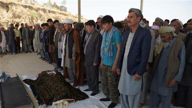 Afghan mourners and relatives pray in front of the coffin of one of the 26 victims killed in a car bombing in Kabul on July 25, 2017. (Photo by AFP)
