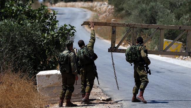 Israeli soldiers close a gate leading to the village of Dayr Abu Mash’al near the West Bank city of Ramallah, on June 17, 2017, following a deadly attack in the al-Aqsa Mosque compound. (Photo by AFP)
