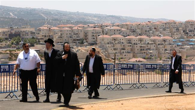 Ultraorthodox Israelis walk at the site of a groundbreaking ceremony for a new neighborhood in the Beitar Illit settlement, in Tel Aviv-occupied West Bank, August 3, 2017. (Photo by AFP)
