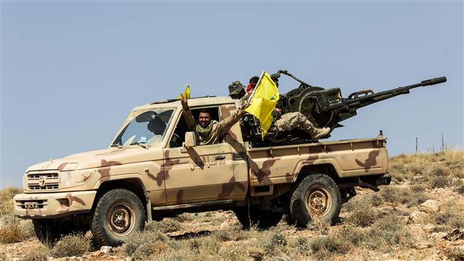 A picture taken on July 26, 2017 during a tour guided by the Lebanese Hezbollah resistance movement shows members of the group manning an anti-aircraft gun mounted on a pick-up truck in a mountainous area around the Lebanese town of Arsal along the border with Syria. (Photo by AFP)

