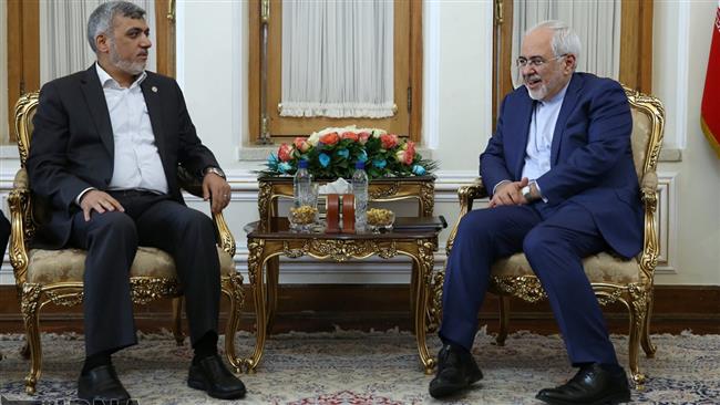 Iran’s Foreign Minister Mohammad Javad Zarif (R) and a member of Hamas