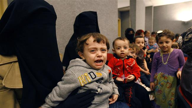 Syrian children wait for vaccinations against polio at one of the Syrian refugee camps in the southern Lebanese port city of Sidon on November 7, 2013.
