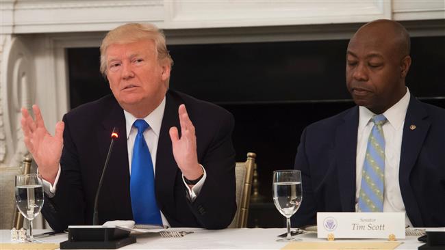 US President Donald Trump speaks alongside Senator Tim Scott (R), Republican of South Carolina, during a meeting with Republican senators to discuss the health care bill in the State Dining Room of the White House in Washington, DC, July 19, 2017. (Photo by AFP)
