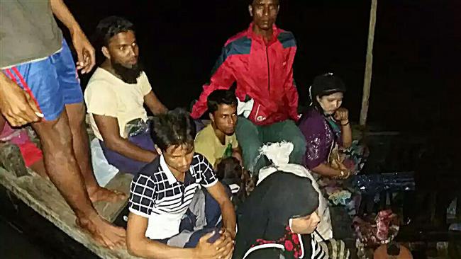 In this handout photograph released by the Bangladesh Coast Guard on August 19, 2017 Rohingya refugees fleeing from Myanmar are sitting in a boat after the coast guard stopped them on the Naf river. (Photo by AFP)