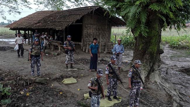 This photo taken on July 14, 2017, shows border police standing guard at Ngayantchaung village, Buthidaung township, in Myanmar