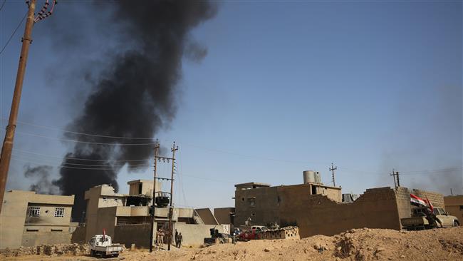 Smoke billows in the background as the Iraqi forces, backed by the Popular Mobilization Units (PMU), commonly known as Hashd al-Sha’abi, advance inside al-Nour neighborhood, in eastern Tal Afar, Iraq, August 23, 2017. (Photo by AFP)
