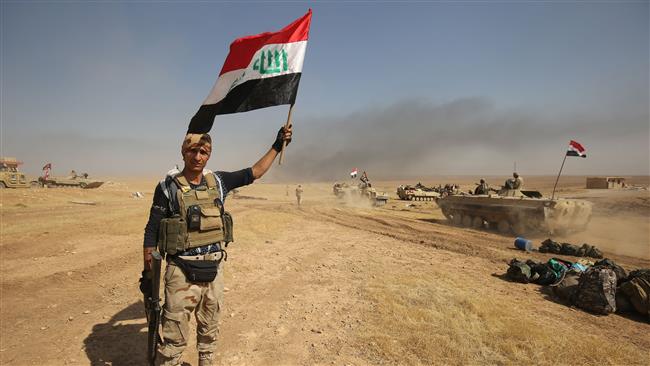 A member of the Iraqi forces poses for a photo holding his national flag as they advance towards the village of al-Ayadieh, near Qubuq, north of Tal Afar, during the ongoing operation to retake the area from Daesh on August 28, 2017. (Photo by AFP)
