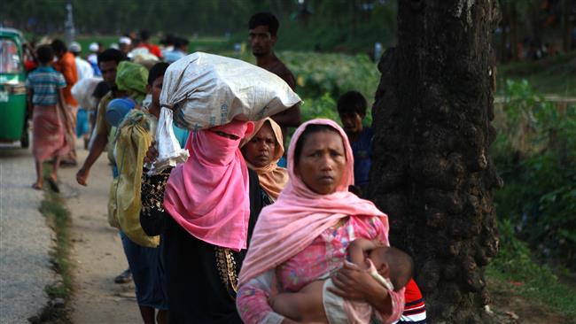 Rohingya Muslim refugees carrying children and their belongings walk in row toward a nearby refugee camp at Ukhiya, Bangladesh, as they flee violence in Myanmar, September 2, 2017. (Photo by AFP)
