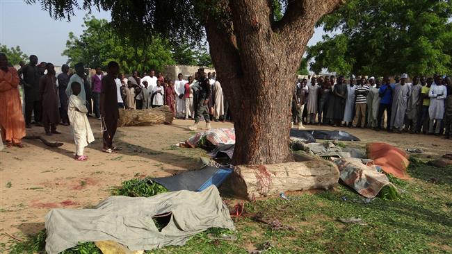 People gather on July 12, 2017 to look at the bodies of victims of an attack after bombers detonated their explosives in Maiduguri on July 11. (Photo by AFP)                      
