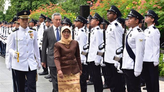 Halimah Yacob making her first inspection of the Guard of Honor, with PM Lee Hsien Loong walking right behind her. 
