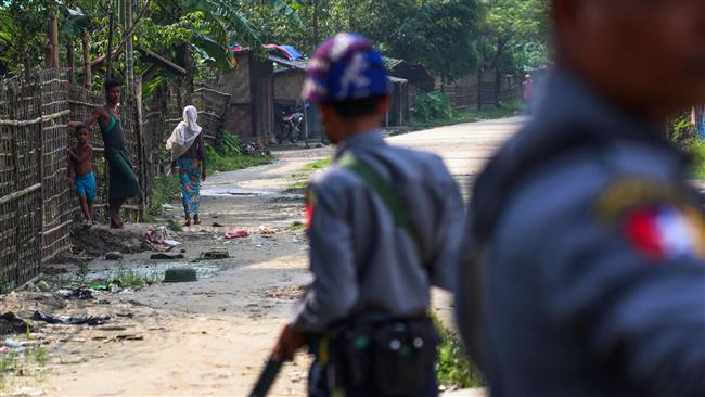 This photo taken on September 6, 2017 shows Rohingya Muslims in the village of Shwe Zarr looking at Myanmar police near Maungdaw township in Rakhine State. (By AFP)
