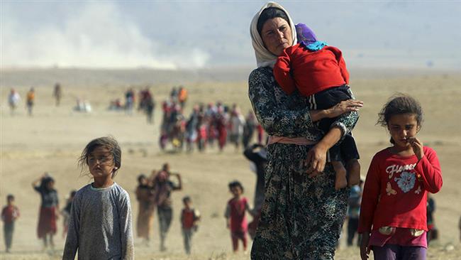 Displaced Yezidis, fleeing violence from Daesh terrorists, head toward the Syrian border in August 2014.
