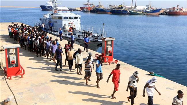 Refugees from Africa walk in line at a naval base in Tripoli after being rescued by Libyan coastguards in the Mediterranean Sea off the Libyan coast on August 29, 2017. (Photo by AFP)
