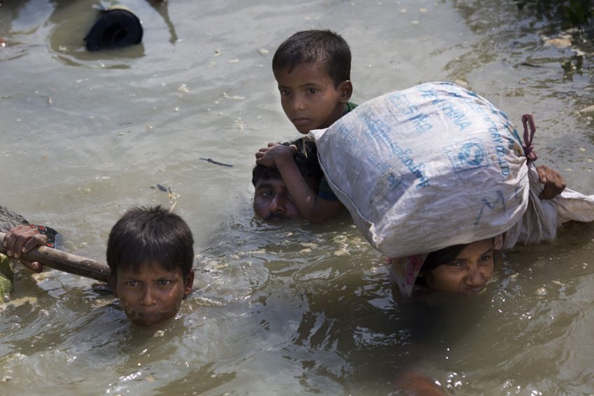 Muslims fleeing ethnic violence in Myanmar crossing a flooded river  

