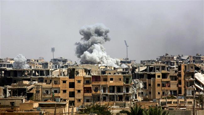 A picture taken on September 5, 2017 shows smoke billowing from a building following a US-led airstrike in the western al-Daraiya neighborhood of the embattled northern Syrian city of Raqqah. (Photo by AFP)
