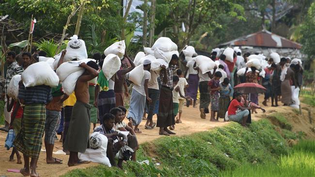Rohingya Muslim refugees carry food distributed by the Bangladeshi army at Balukhali refugee camp near Gumdhum on September 26, 2017. (Photo by AFP)
