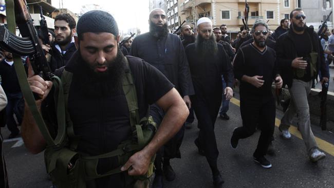 In this file picture, armed supporters of hardcore Lebanese Takfiri preacher Sheikh Ahmad al-Assir (front row 3rd R) escort him and former Lebanese singer Fadl Shaker (front row 2nd R) during the funeral of two of Assir