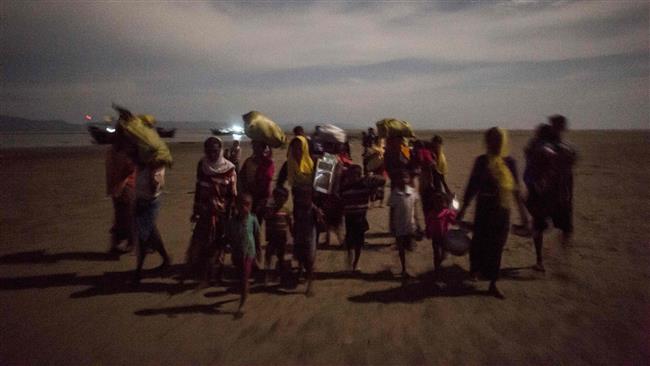 Rohingya Muslim refugees walk by night after crossing the border from Myanmar, on the Bangladeshi shores of the Naf river in Teknaf on September 29, 2017. (Photo by AFP)
