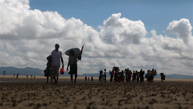 Rohingya Muslim refugees walk on the Bangladeshi shoreline of the Naf River after crossing the border from Myanmar, in Teknaf, on September 30, 2017. (Photo by AFP)
