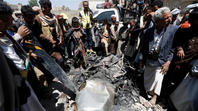 People gather around the engine of an unmanned aerial vehicle, which Houthi Ansarullah fighters said they downed in Sana’a, Yemen, on October 1, 2017. (Photo by Reuters)
