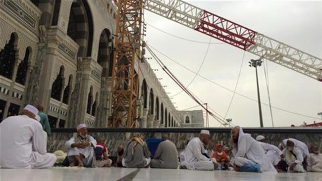 Muslim pilgrims sit in front of the crane that collapsed the day before at the Grand Mosque in Saudi Arabia