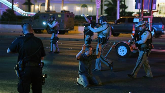 Police officers stop a man who drove down Tropicana Ave. near Las Vegas Boulevard and Tropicana Ave, which had been closed after a mass shooting at a country music festival that left at least 59 people dead nearby on October 1, 2017 in Las Vegas, Nevada. (Photo by AFP)
